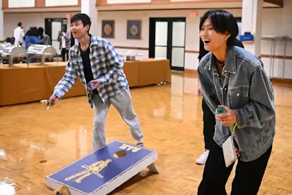 Two WVU international students playing cornhole.